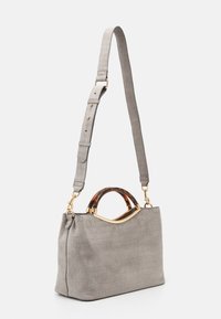 Grijze croco-embossed handtas met een gestructureerde vorm, voorzien van een schildpad-look handvat en een gouden accent. Verstelbare schouderband.