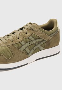 Olive green sneaker made of suede and mesh, featuring lace-up closure, contrast detailing, and a white midsole with black outsole.