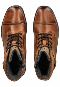 Botas de tobillo de piel marrón con cordones negros, forro texturizado y puntera redondeada. Incluyen cremalleras laterales y una suela de goma negra resistente.