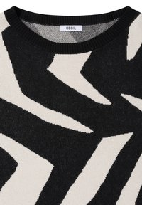 Neulottu neulepaita pyöreällä pääntiellä. Musta ja kerma valkoinen siksak-kuvio teksturoidussa kankaassa, jossa hienovaraisesti metallinhohtoisia lankoja koko pinnalla.