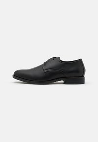 Chaussure habillée en cuir noir avec un embout arrondi, finition lisse, design lacé minimaliste et un talon bas.