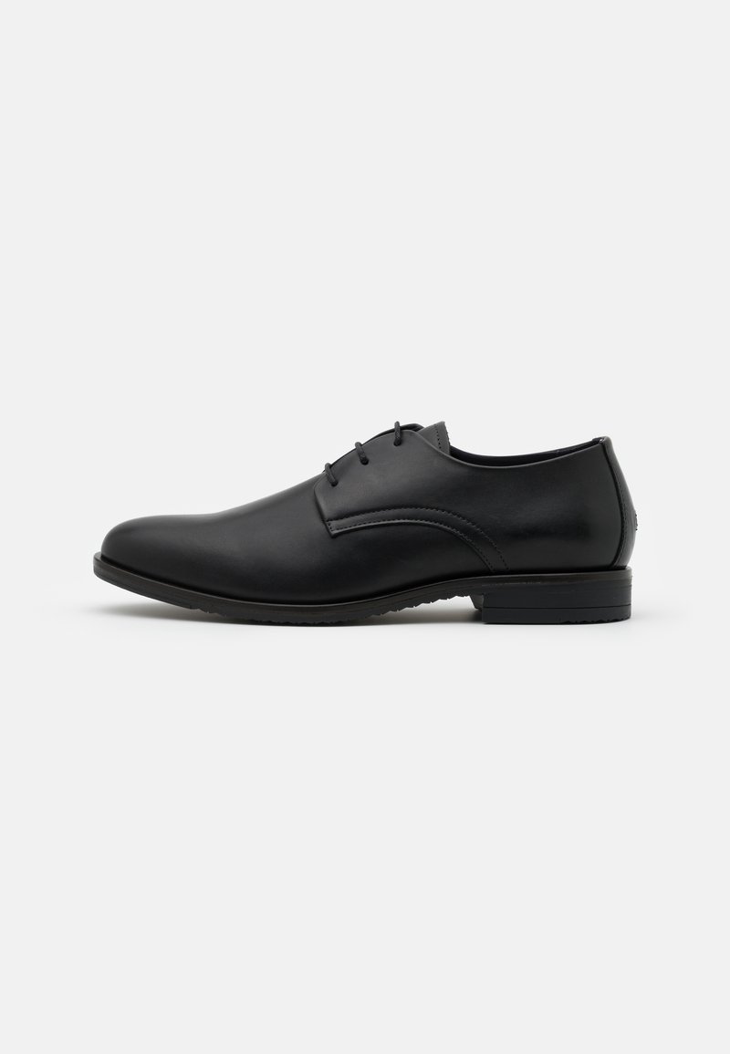 Chaussure habillée en cuir noir avec un embout arrondi, finition lisse, design lacé minimaliste et un talon bas.