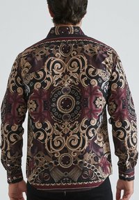 Chemise à manches longues dans des tons sombres, ornée d'un motif complexe doré et bordeaux avec des designs ornés et des détails semblables à des bijoux.