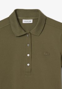 Polo shirt verde oliva realizzato in cotone testurizzato, con patta a tre bottoni, logo ricamato e colletto morbido.