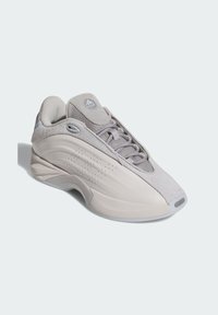 Gray athletic shoe with a mix of suede and mesh materials. Features rounded design, lace-up closure, and subtle perforations on the side.