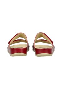 Sandales en cuir rouge avec une finition lisse, deux larges sangles qui traversent le pied et une semelle en caoutchouc beige et basse. L'intérieur est beige.