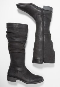 Bottes noires en cuir montant jusqu'au genou avec un design décontracté, dotées d'une fermeture éclair latérale et d'un petit talon bloc. Texture lisse avec des coutures minimales.