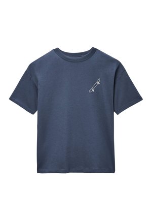 T-shirt bleu marine à manches courtes et col rond avec un petit graphique blanc de skateboard sur le côté gauche de la poitrine.