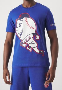 Modré bavlněné tričko s velkým kresleným baseballovým charakterem v kšiltovce, orámovaným červeně, s textem "Mets" pod postavou.