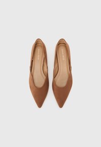 Ballerines en suède marron à bout pointu avec des côtés découpés. Doublure intérieure lisse et design minimaliste, adaptées à diverses occasions.