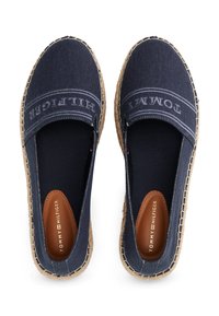 Tengerészkék vászon espadrille cipők steppelt részletekkel, bézs juta talpakkal és bőr belső talppal, amelyen a "TOMMY HILFIGER" logó található.
