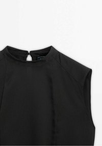 Blouse noire sans manches avec un col haut et une petite ouverture avec fermeture par bouton dans le dos.