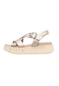 Sandali metallici dorati con cinturini incrociati, chiusura con fibbia e suola spessa beige con scanalature testurizzate. Nome del marchio impresso sul lato.