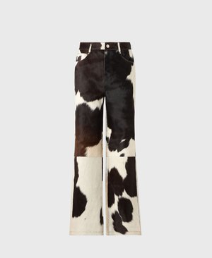 Cowhide flared pants featuring a patchwork design in black and white colors, with a smooth texture and visible stitching accents.