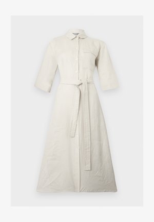 Bordinės smėlio spalvos ilgų marškinių su trimis ketvirčiais rankovėmis, priekyje sagos, krūtinės kišenė, apykaklė ir prie juosmens surištas diržas iš tokios pat medžiagos.