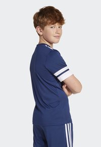 T-shirt de sport bleu marine avec des accents blancs, à manches courtes et à col rond. Texture lisse adaptée aux activités sportives.