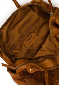 Sac à main en cuir marron avec une texture tissée, des poches zippées et une doublure en tissu doux. Comprend une étiquette indiquant "Cuir véritable."