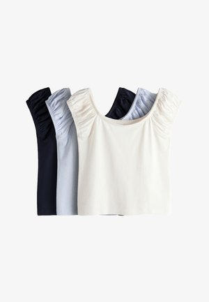 Tres tops de manga corta con hombros fruncidos en negro, azul claro y blanco, dispuestas superpuestas sobre un fondo blanco.