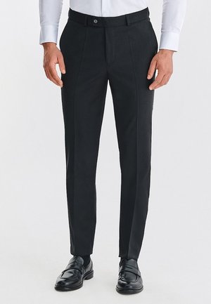 Czarne spodnie materiałowe wykonane z gładkiego materiału, z prostymi nogawkami, plisami oraz paskiem z zapięciem na guzik.