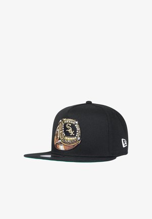 Berretto snapback nero Chicago White Sox con design ricamato di anello di campionato oro e bianco sul pannello frontale.