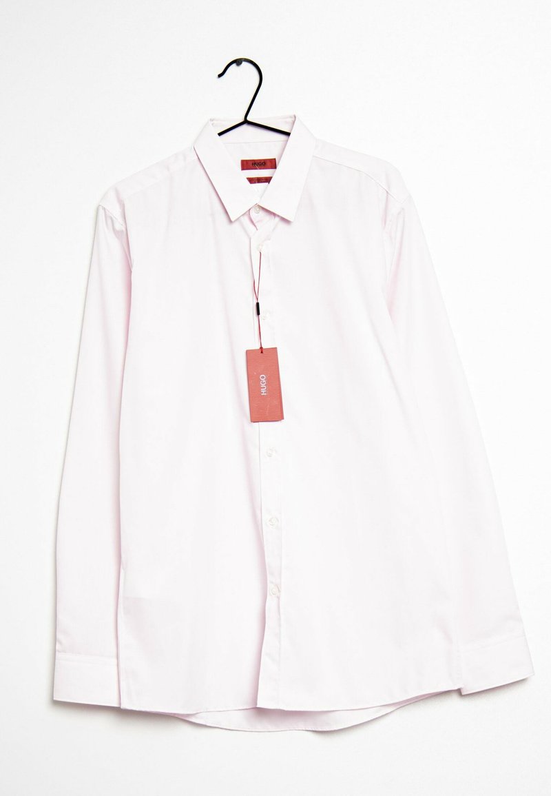 Camisa de manga larga rosa claro con cuello abotonado, que presenta un dobladillo redondeado y una etiqueta unida al cuello.