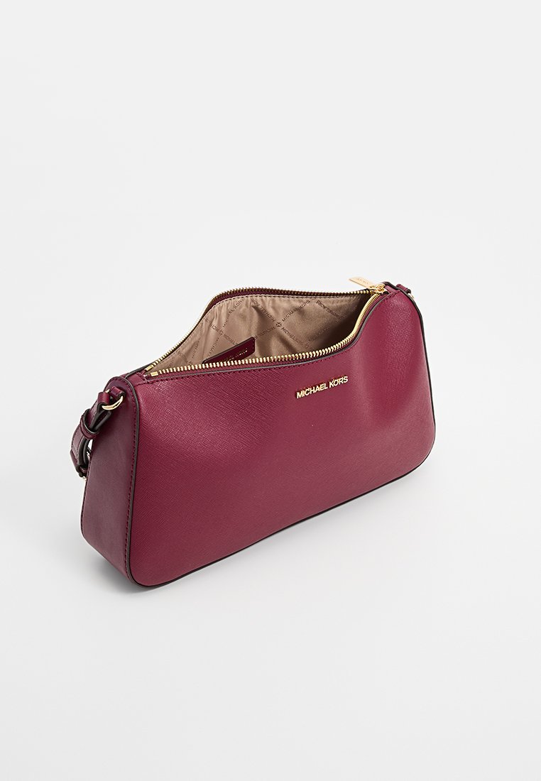 Borsa a tracolla in pelle borgogna, con una finitura morbida e testurizzata, hardware dorato e chiusura con zip. L'interno è in tessuto color crema.