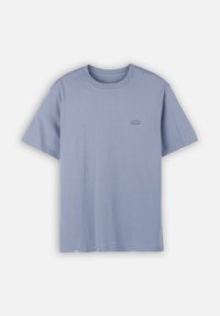 T-shirt unisexe à manches courtes et col rond de couleur bleu pastel avec un petit logo "Oxbow" sur la poitrine gauche et une étiquette près de l'ourlet inférieur.
