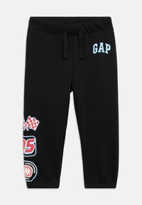Fekete szabadidőnadrág rugalmas derékpánttal és húzózsinórral, alján kék "GAP" felirattal és színes versenyautós grafikával.