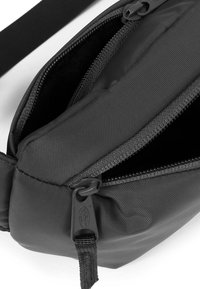 Borsa di tessuto nera con diverse comparti con cerniera. Presenta una superficie liscia, una ferramenta robusta e una tracolla removibile per maggiore comodità.