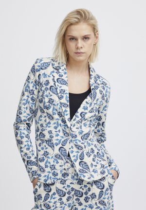 White blazer with blue floral and paisley pattern, featuring a single-button closure and two front pockets. Paired with a black top.