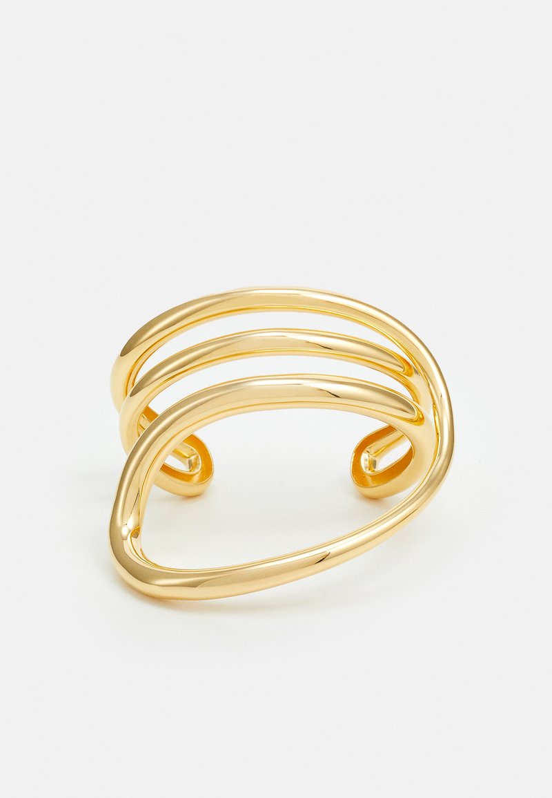 Kuldsest metallist käevõru, millel on kolm lainelist, siledat riba ümarate otstega. Kujundus on minimalistik ja sujuv, millel on poleeritud pind.