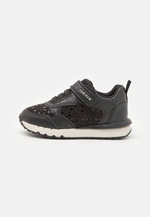 Sort børnesneaker med plettet ruskind, velcrolukning mærket "GEOX" og hvid sål på ensartet lys baggrund.