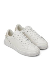 Sneakers in pelle bianca con punta arrotondata, design perforato, lacci piatti e suola in gomma. Presentano cuciture sottili e un tallone testurizzato.
