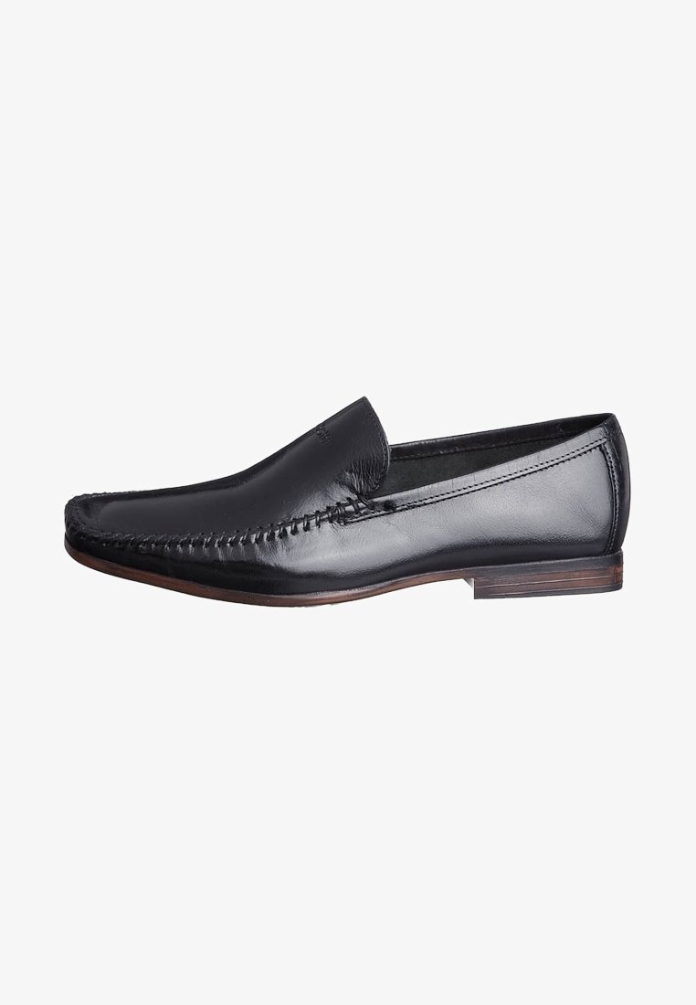 Mocassins en cuir noir avec un design cousu sur le devant, une finition lisse, un talon bas et un bout arrondi, offrant une apparence classique et élégante.