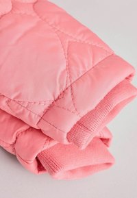 Rosa gesteppten Fäustlinge mit glattem Stoff und gerippten Bündchen, einer weichen Textur und gleichmäßigen Nähten für zusätzliche Haltbarkeit.