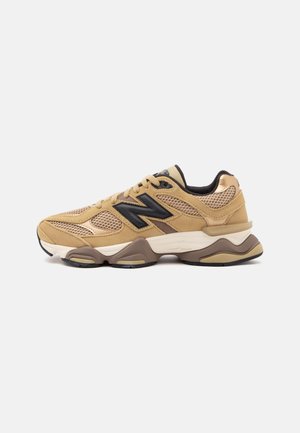 Sneaker beige e marrone con pannelli in mesh, suola spessa, fodera interna nera e grande logo nero "N" sul lato.
