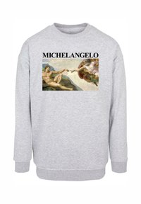 Tricou gri cu un print al lucrării lui Michelangelo, cu textul "MICHAELANGELO" deasupra imaginii. Mansete și tiv cu nervuri.