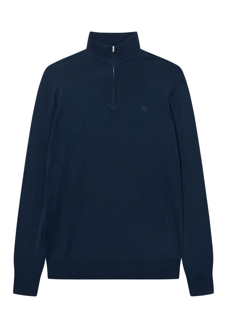 Sötétkék, hosszú ujjú pulóver fél cipzáras gallérral. Puha anyagból készült, bal mellkason diszkrét logóval. Simaság jellemzi.