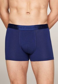 Mornarsko modri boksarji iz mehke tkanine. Imajo teksturiran pas s potiskom "TOMMY HILFIGER". Klasičen kroj, nudi popolno pokritost.