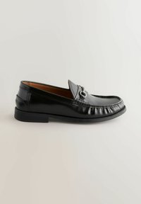 Sorte læder loafers har en rund tå, syede detaljer og en enkel metalaccent på vamps. Flad gummisål for komfort.
