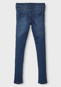 Skinny denim jeans in dark blue, featuring a mid-rise waist, five-pocket design, and subtle stitching details on the back pockets.