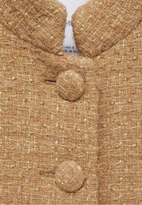 Manteau en tissu tissé couleur fauve avec des boutons recouverts du même tissu et un col à encoches.