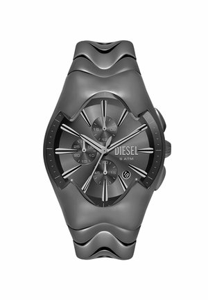 Montre en silicone grise avec un large bracelet ondulé. Le cadran noir rond présente des index en argent, trois sous-cadrans et une fenêtre de date à 6 heures.