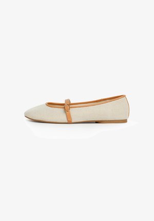 Zapato Mary Jane plano beige con ribete marrón claro y correa ajustable, con una superficie de tela texturizada y una suela de tacón bajo.