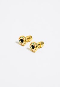 Pendientes de perno en tono dorado con diseño circular, que presentan un corazón negro en el centro y letras de colores alrededor del borde que dicen 'BIMBA Y LO'.
