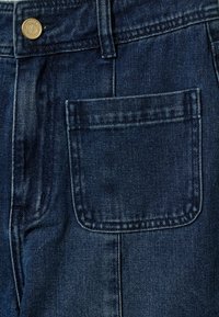 Traperice kratke hlače u tamnoplavoj boji, s kopčanjem na gumbe sprijeda, petljama za pojas i jednim zakačenim džepom na stražnjoj strani sa detaljima šivanja.