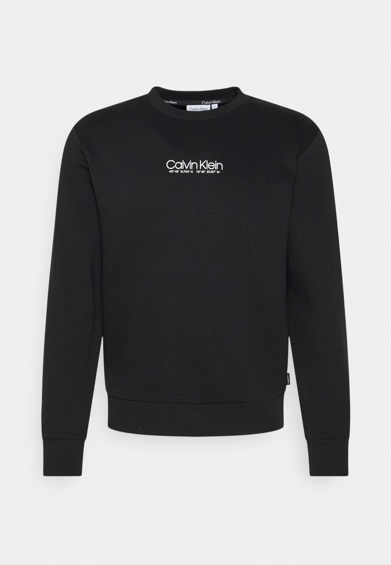 Sweat-shirt noir en coton, avec un col rond, des poignets côtelés et un logo blanc "Calvin Klein" sur le devant.