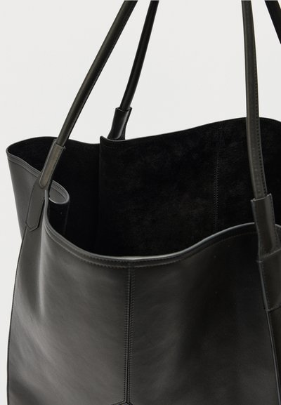 Sac fourre-tout en cuir noir avec deux longues anses et une doublure intérieure douce, semblable au daim.
