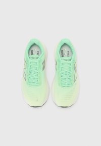 Sneakers with a light mint green upper, mesh texture, laces, and reflective grey accents. Cushioned sole for comfort and flexibility.