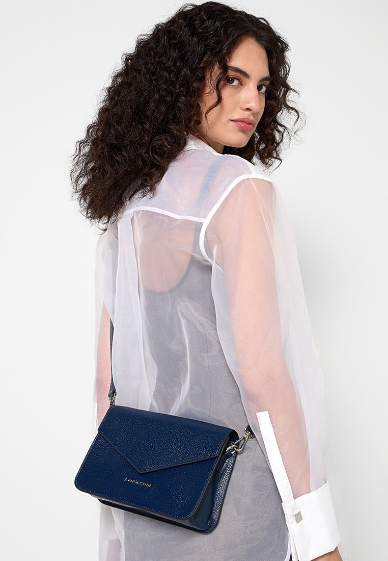 Navyfarbene Leder-Crossbody-Tasche mit strukturiertem Finish, Klappenverschluss und silbernem Beschlag. Enthält einen Schulterriemen und ein geprägtes Logo-Detail.